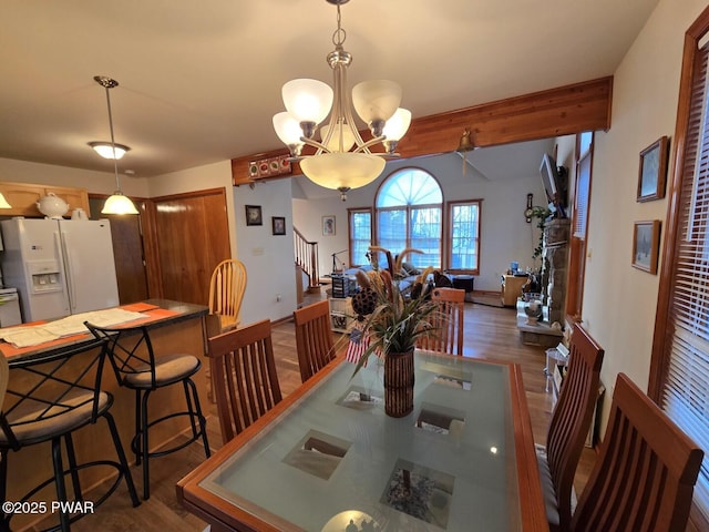 dining area with dark wood finished floors, beam ceiling, a notable chandelier, and baseboards