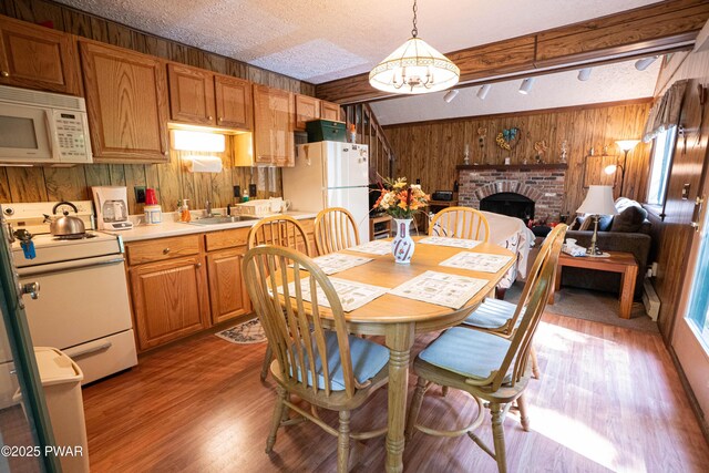 28 Lakewood Dr, Lake Ariel, PA 18436 - dining room with wooden walls, light wood-style flooring, a fireplace, a textured ceiling, and beamed ceiling