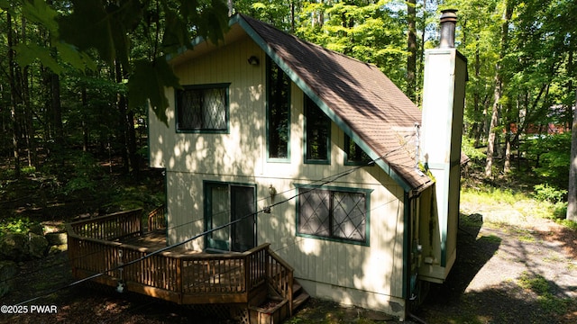28 Lakewood Dr, Lake Ariel, PA 18436 - view of side of home featuring a deck, a shingled roof, and a chimney
