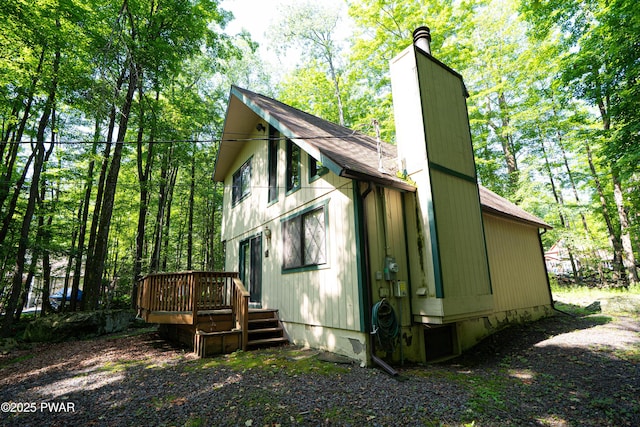 28 Lakewood Dr, Lake Ariel, PA 18436 - view of side of home featuring a chimney, a shingled roof, and a deck