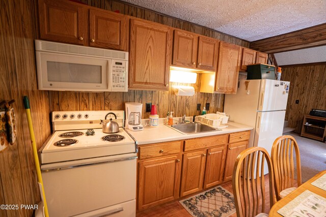 28 Lakewood Dr, Lake Ariel, PA 18436 - kitchen featuring white appliances, wooden walls, a textured ceiling, light countertops, and brown cabinetry