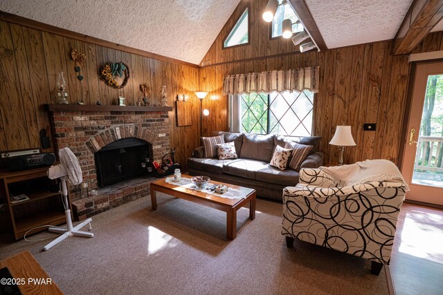 28 Lakewood Dr, Lake Ariel, PA 18436 - living room featuring a textured ceiling, wooden walls, plenty of natural light, vaulted ceiling, and a fireplace