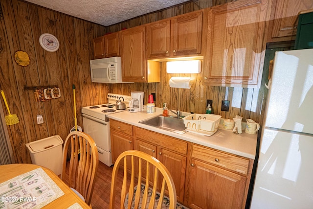 28 Lakewood Dr, Lake Ariel, PA 18436 - kitchen with white appliances, wood walls, light countertops, a textured ceiling, and wood finished floors