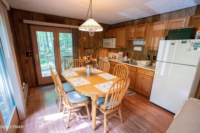 28 Lakewood Dr, Lake Ariel, PA 18436 - dining room featuring wooden walls, light wood-style flooring, and a textured ceiling