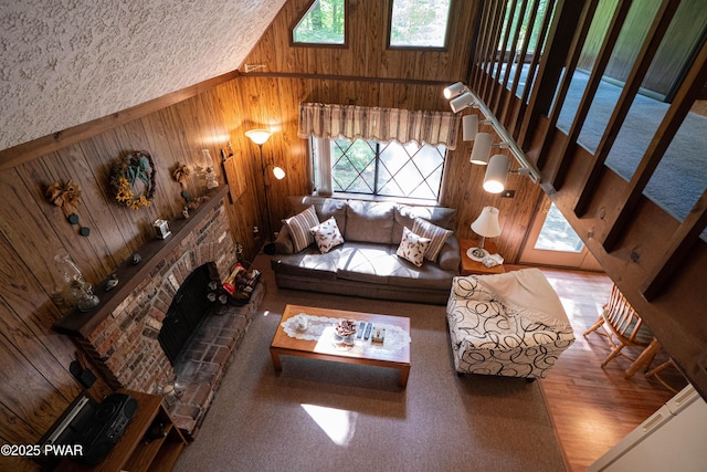 28 Lakewood Dr, Lake Ariel, PA 18436 - living area featuring wood walls, healthy amount of natural light, a fireplace with raised hearth, and a high ceiling