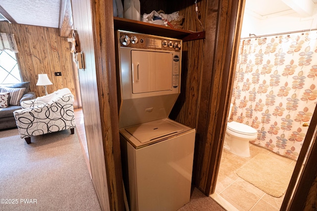 28 Lakewood Dr, Lake Ariel, PA 18436 - laundry area featuring stacked washing machine and dryer, wood walls, and a textured ceiling