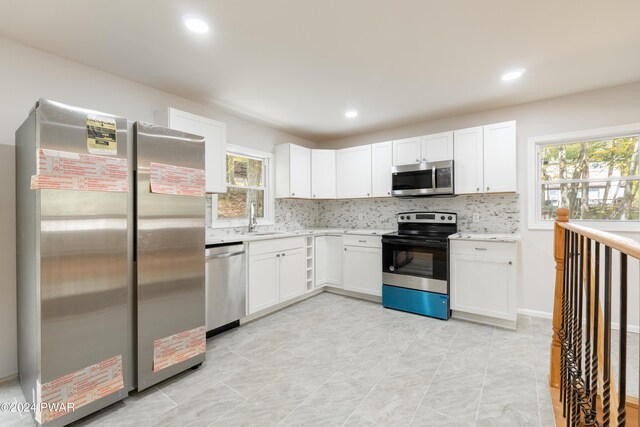 kitchen with white cabinets, plenty of natural light, sink, and appliances with stainless steel finishes