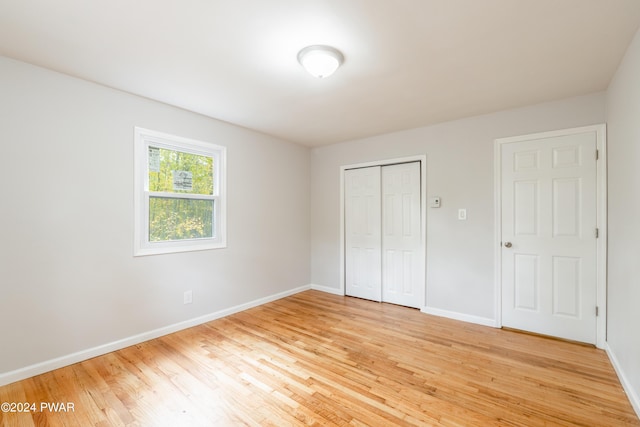 unfurnished bedroom featuring wood-type flooring and a closet