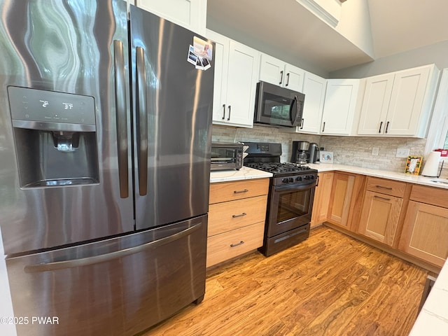 1006 Redlawn Ln, Lake Ariel, PA 18436 - kitchen with appliances with stainless steel finishes, light wood-style floors, tasteful backsplash, and white cabinetry