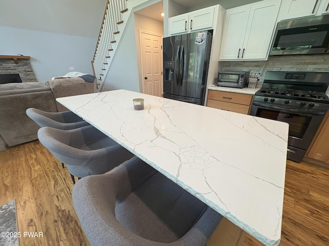 1006 Redlawn Ln, Lake Ariel, PA 18436 - kitchen featuring gas range, refrigerator with ice dispenser, light stone counters, stainless steel microwave, and light wood-style flooring