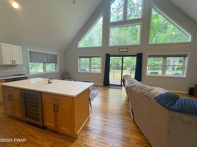 1006 Redlawn Ln, Lake Ariel, PA 18436 - kitchen featuring open floor plan, high vaulted ceiling, beverage cooler, a kitchen island, and light stone counters