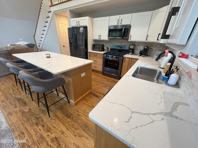 1006 Redlawn Ln, Lake Ariel, PA 18436 - kitchen with stainless steel appliances, light wood finished floors, backsplash, light stone countertops, and a breakfast bar