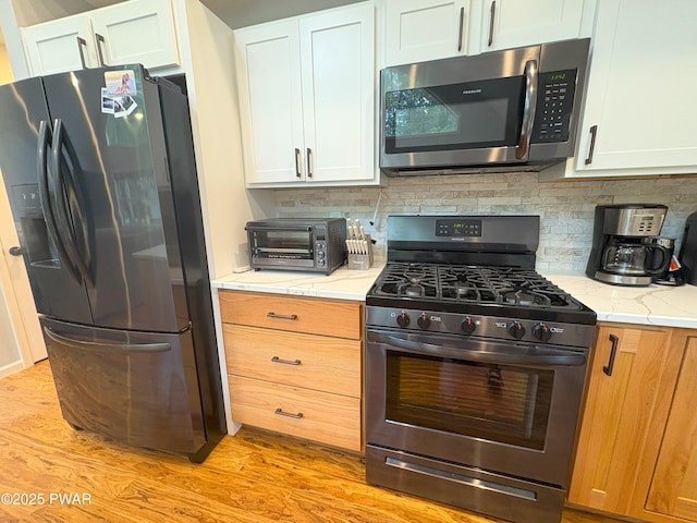 1006 Redlawn Ln, Lake Ariel, PA 18436 - kitchen featuring appliances with stainless steel finishes, tasteful backsplash, light stone countertops, and light wood-style floors