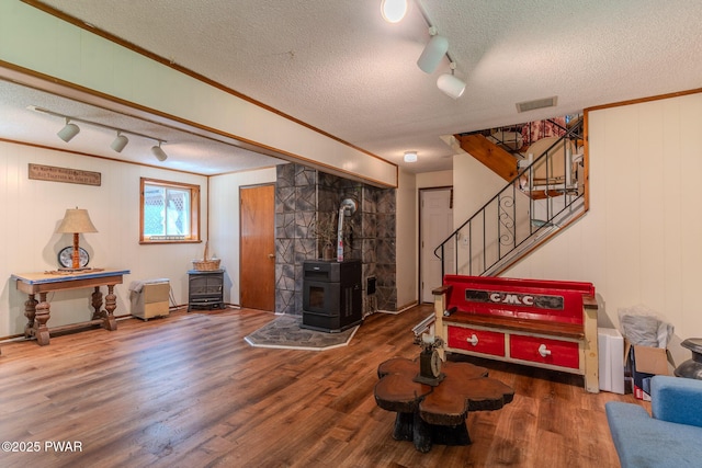 53 Windsor Rd, Hawley, PA 18428 - living room featuring a textured ceiling, rail lighting, a wood stove, wood finished floors, and stairs