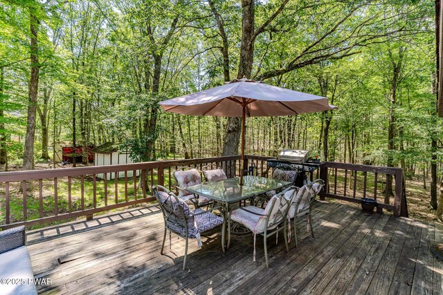 53 Windsor Rd, Hawley, PA 18428 - deck with outdoor dining space, a storage unit, and a forest view