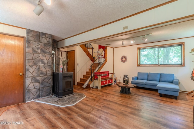 53 Windsor Rd, Hawley, PA 18428 - living area with wood finished floors, a textured ceiling, stairway, ornamental molding, and a wood stove