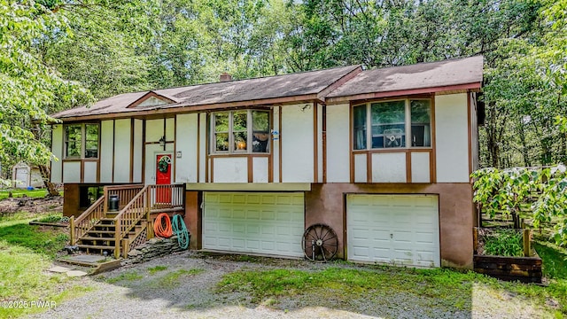 53 Windsor Rd, Hawley, PA 18428 - bi-level home featuring a garage, gravel driveway, and stucco siding