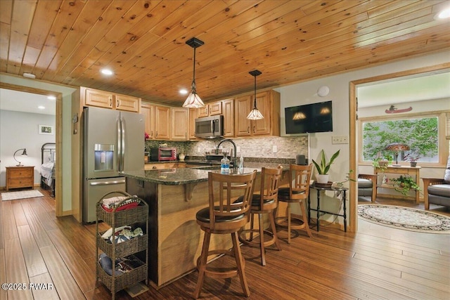 1057 K Ln, Gouldsboro, PA 18424 - kitchen featuring stainless steel appliances, a peninsula, dark wood-style flooring, decorative backsplash, and a breakfast bar