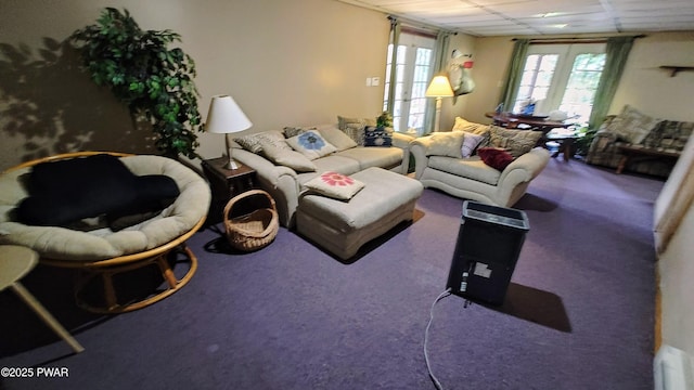 carpeted living room with a paneled ceiling