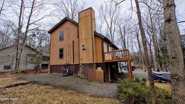 back of property featuring a wooden deck, central air condition unit, and a chimney