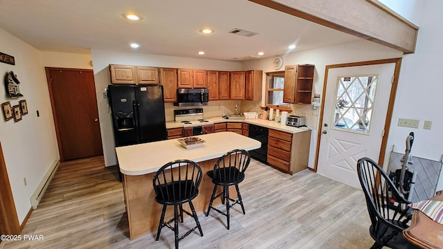 kitchen featuring a kitchen bar, black appliances, open shelves, a baseboard heating unit, and light wood finished floors