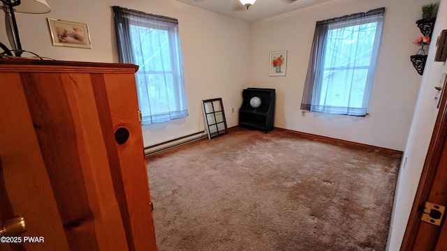 unfurnished bedroom featuring multiple windows, carpet floors, baseboards, and a baseboard radiator