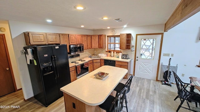 kitchen featuring visible vents, black appliances, light countertops, and open shelves