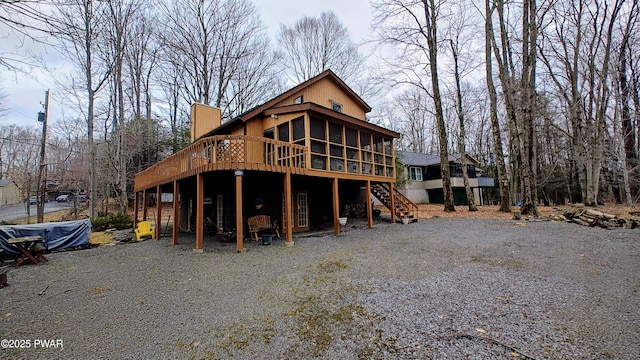 view of front of home featuring stairs, a deck, and a sunroom