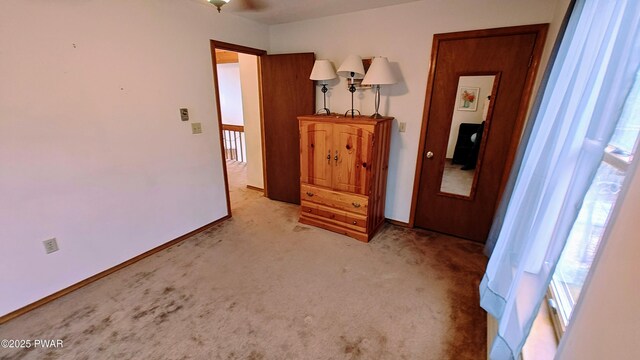 bedroom featuring light colored carpet and baseboards