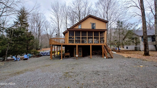 view of front of property with a deck, stairway, and a sunroom