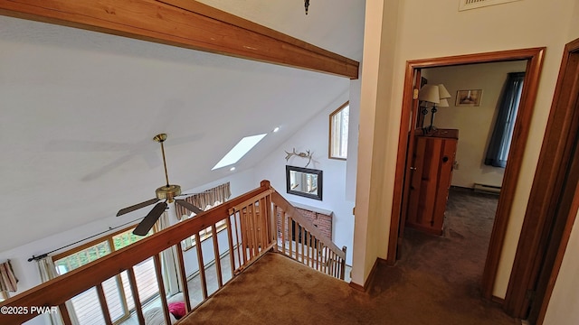 hall featuring a wealth of natural light, vaulted ceiling with skylight, and carpet floors