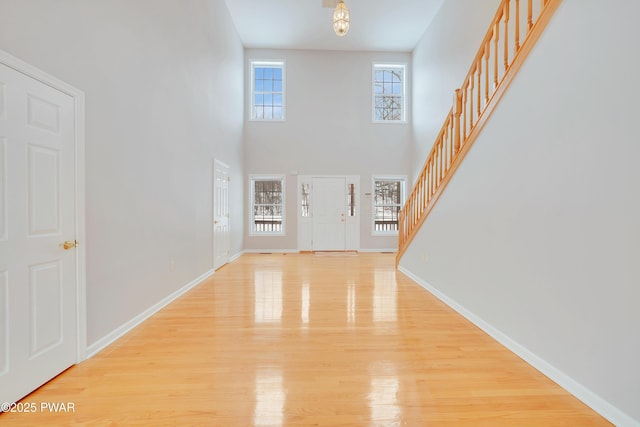 129 Lakewood Dr, Dingmans Ferry, PA 18328 - foyer entrance with stairs, light wood-style floors, and a towering ceiling