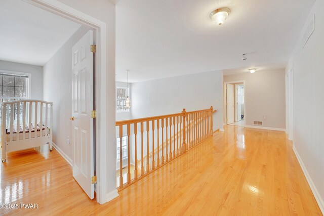 129 Lakewood Dr, Dingmans Ferry, PA 18328 - corridor featuring an upstairs landing, wood finished floors, healthy amount of natural light, and a chandelier