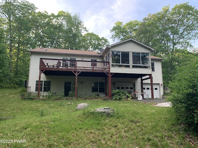 back of property with a lawn, an attached garage, and a wooden deck