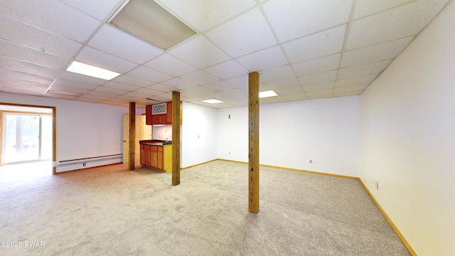 below grade area with a baseboard radiator, light carpet, and baseboards