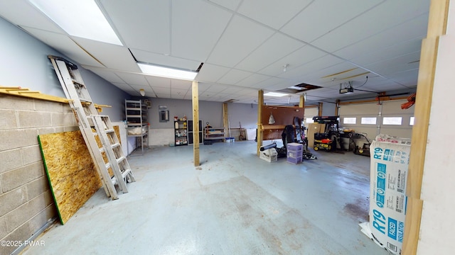 garage featuring concrete block wall and a garage door opener