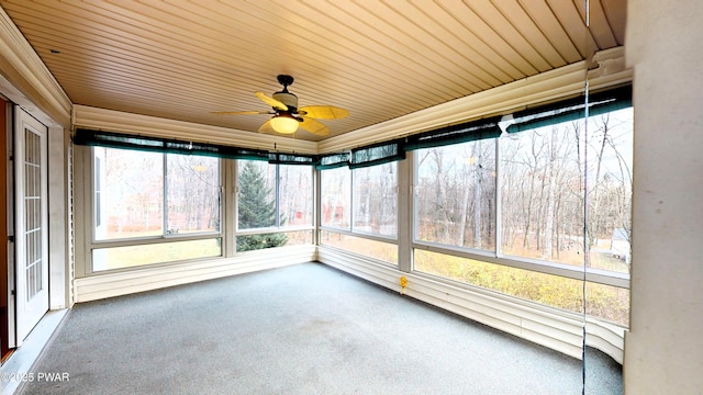 unfurnished sunroom featuring wood ceiling and a ceiling fan