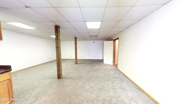 finished basement with carpet flooring, baseboards, and a drop ceiling