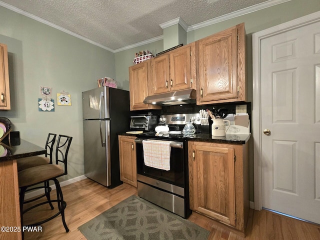 127 Maxatawny Dr, Pocono Lake, PA 18347 - kitchen featuring appliances with stainless steel finishes, under cabinet range hood, dark countertops, light wood-type flooring, and a textured ceiling