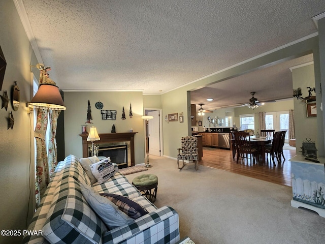 127 Maxatawny Dr, Pocono Lake, PA 18347 - living room with ornamental molding, a textured ceiling, light colored carpet, a glass covered fireplace, and a ceiling fan