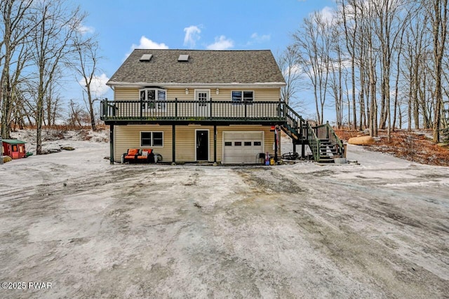 back of house featuring a deck, stairs, and a garage