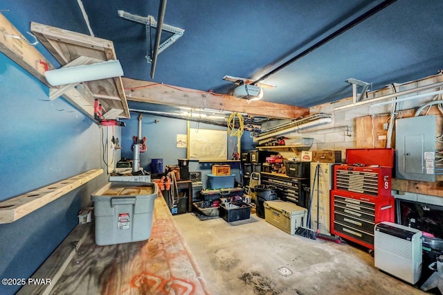 garage featuring electric panel, a workshop area, and a garage door opener