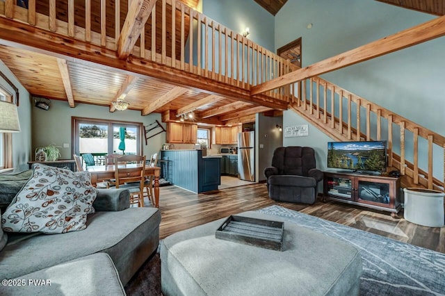 living room featuring wood finished floors, stairway, beamed ceiling, and wooden ceiling
