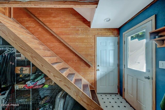 stairs featuring wooden walls and tile patterned floors