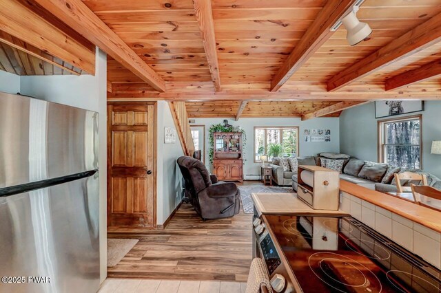 living area with light wood finished floors, beamed ceiling, and wooden ceiling