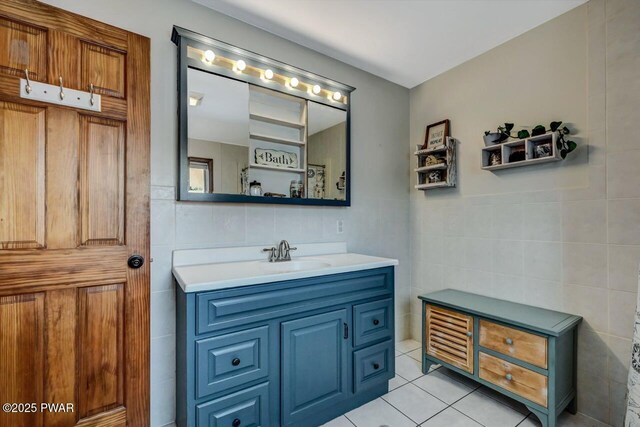 bathroom with tile walls, vanity, and tile patterned flooring