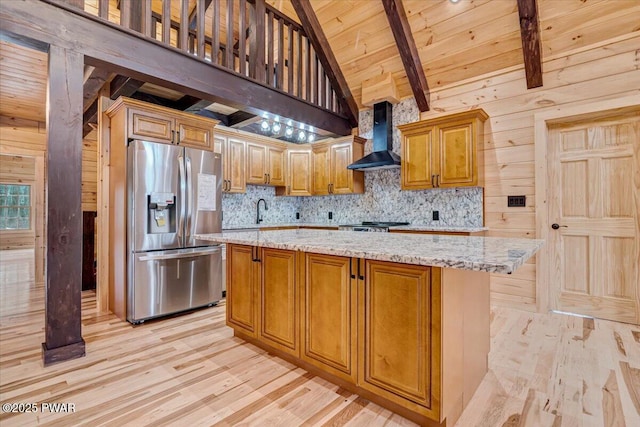 kitchen with a center island, wall chimney exhaust hood, beamed ceiling, stainless steel fridge, and wood ceiling