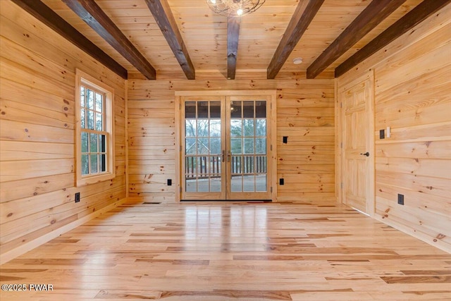 empty room featuring wood walls, french doors, beamed ceiling, and wooden ceiling