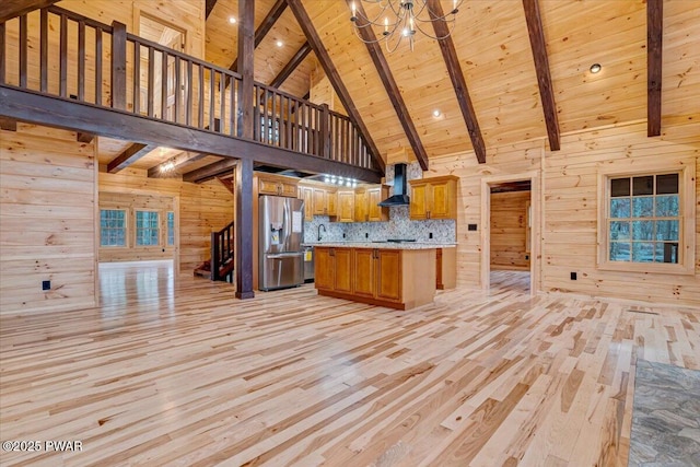 unfurnished living room featuring wooden ceiling, high vaulted ceiling, wooden walls, light wood-type flooring, and beam ceiling