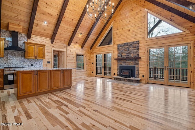 kitchen featuring high vaulted ceiling, wall chimney exhaust hood, beamed ceiling, and stainless steel stove